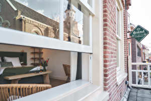 Voorkamer met schuiframen met uitzicht op de dorpskerk.